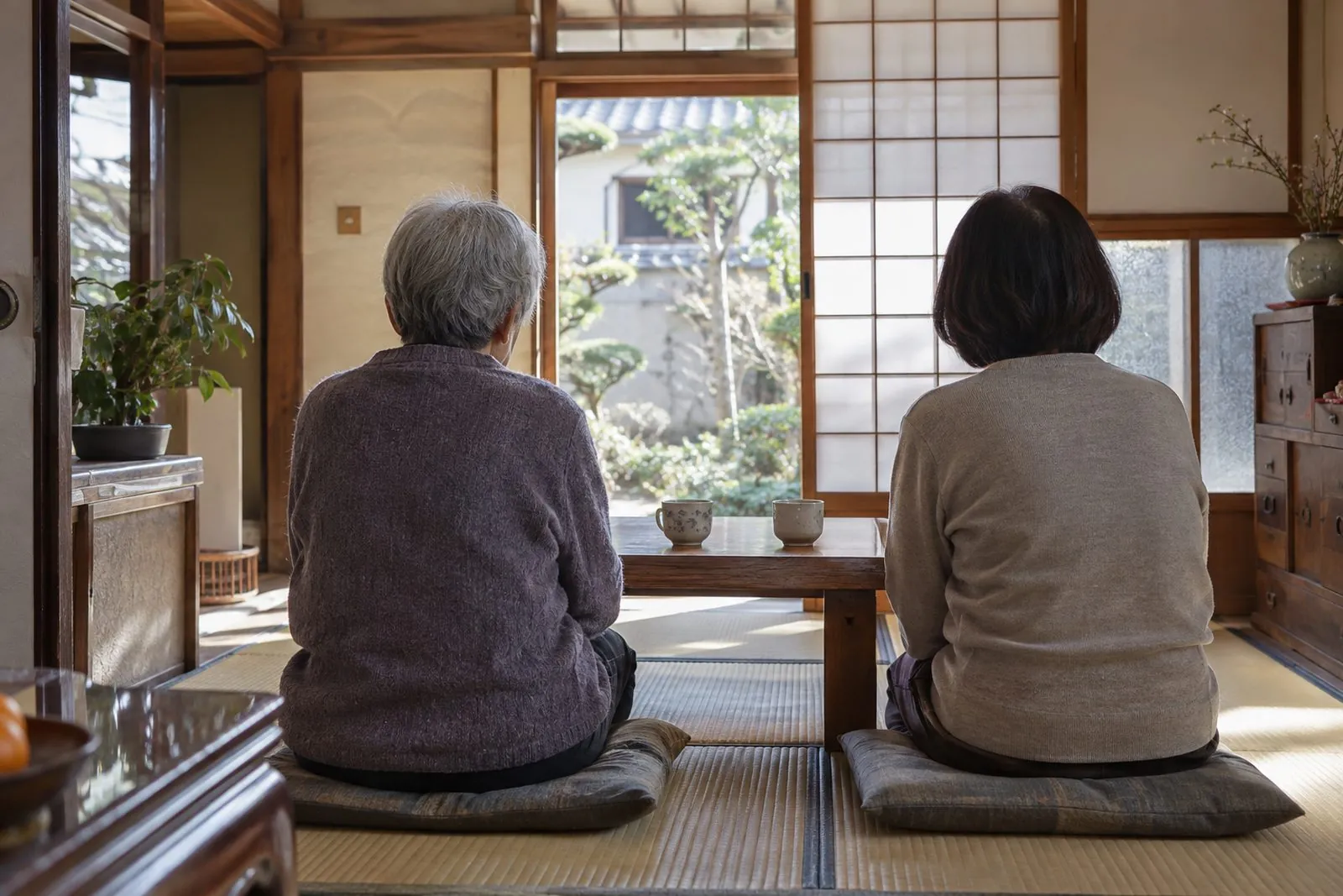 茶の間で並んで座る親子の後ろ姿
