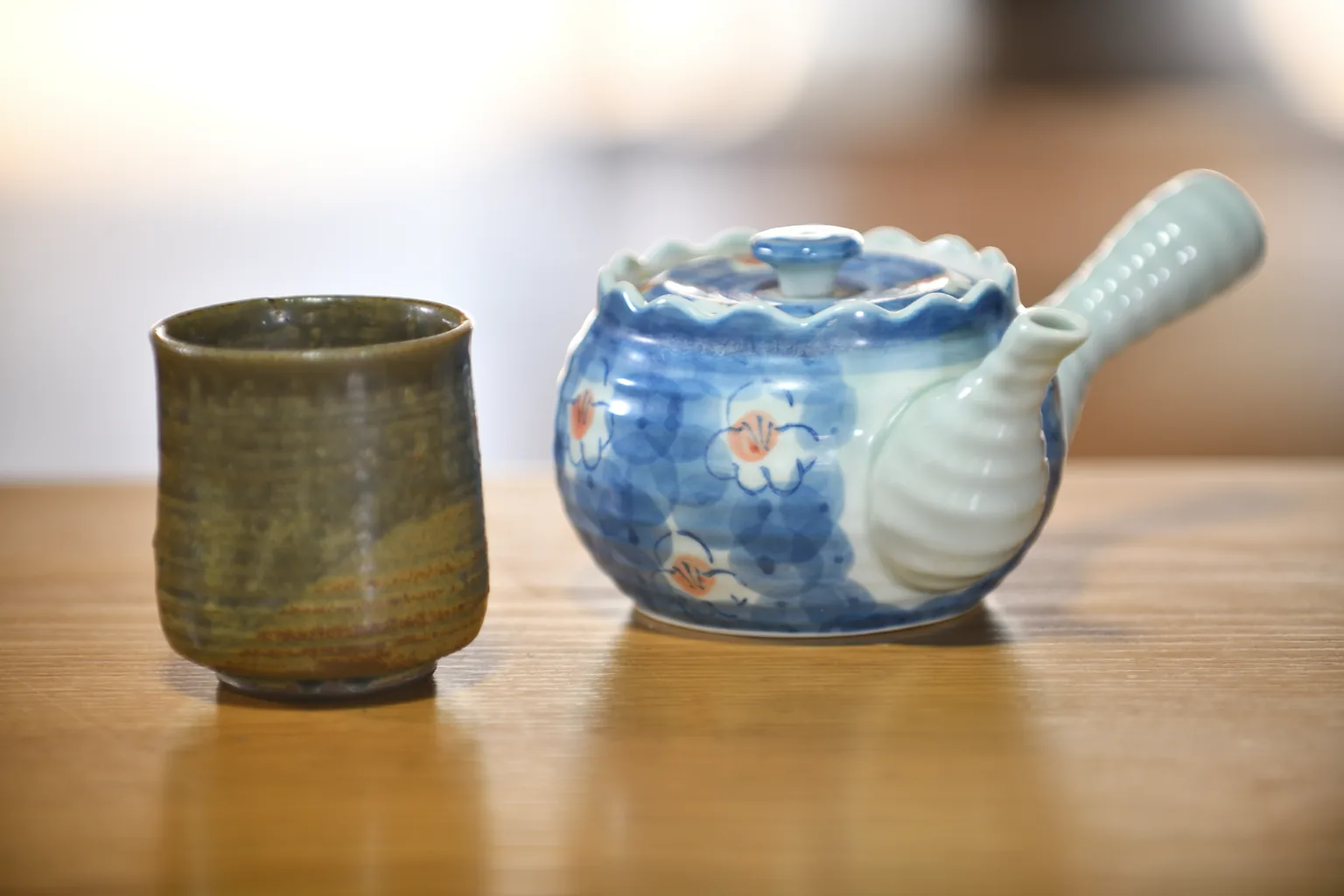 木のテーブルに置かれた急須と湯呑み